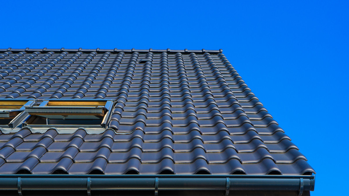 la toiture d'une maison avec velux ouvert sous un ciel bleu